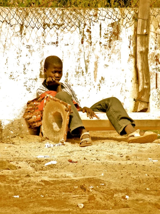 a man sitting down on a wooden bench holding an open drumstick