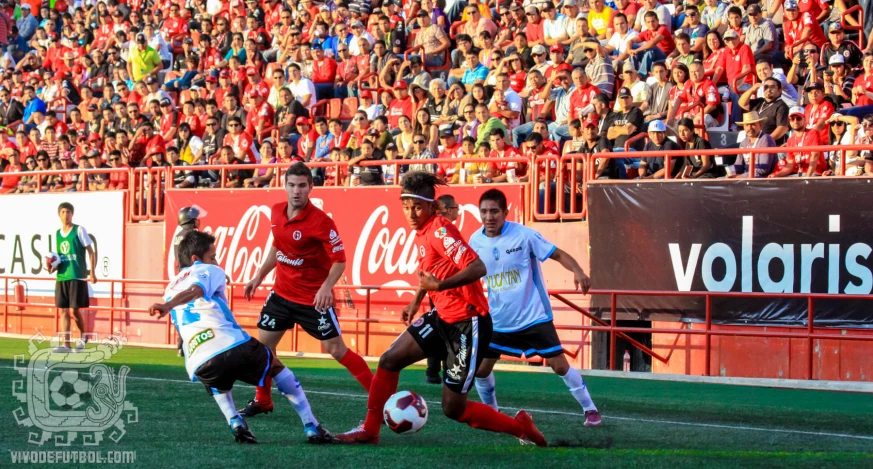 a group of young men playing soccer against each other