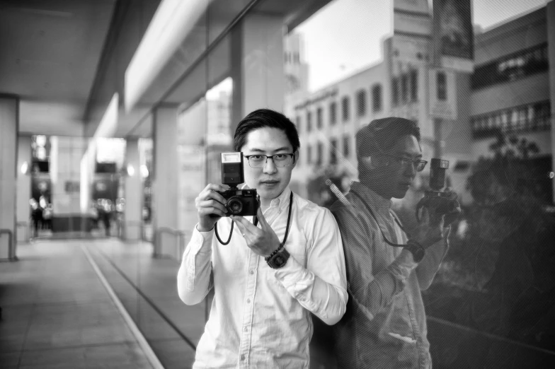 an asian woman holding up a camera