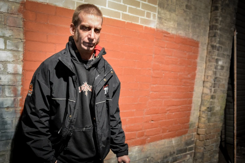 a man in a black jacket smoking a red cigar