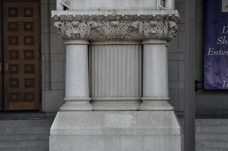 two columns sitting in front of a doorway with a building behind it