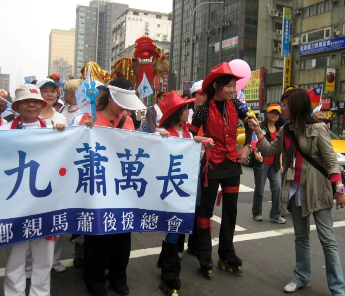 a woman holding a banner with other people marching around