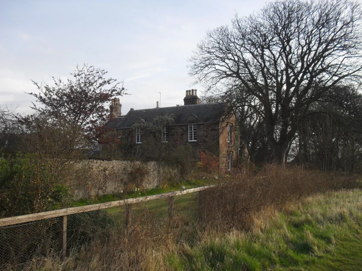 a field near trees and a large building