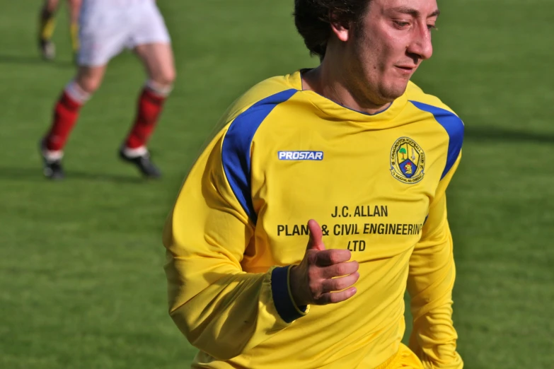 man in yellow jersey running on the soccer field