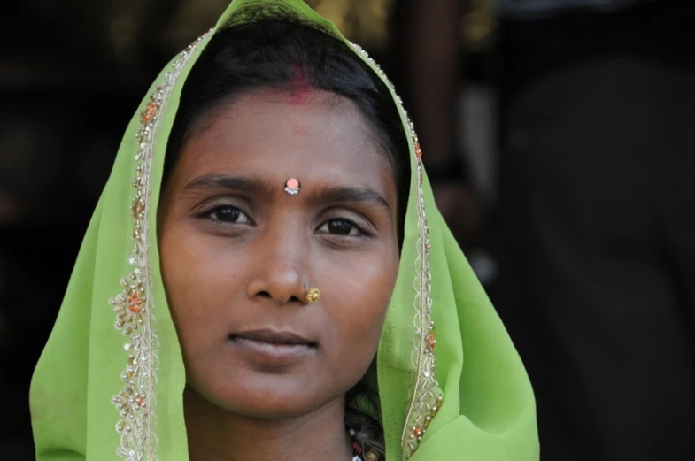 a lady with bright green and gold jewelry