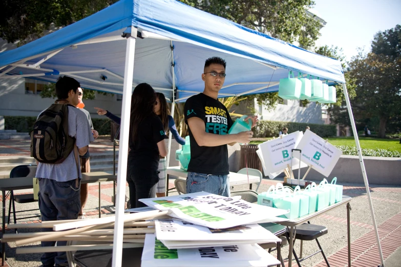 people standing at a tent with items for sale