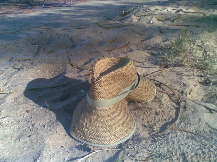 a straw hat lying on a sand dune