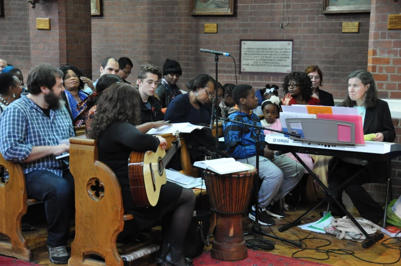 a group of people sit around in chairs watching one woman perform