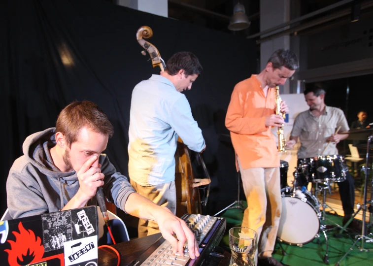 the musician uses his laptop while playing on stage