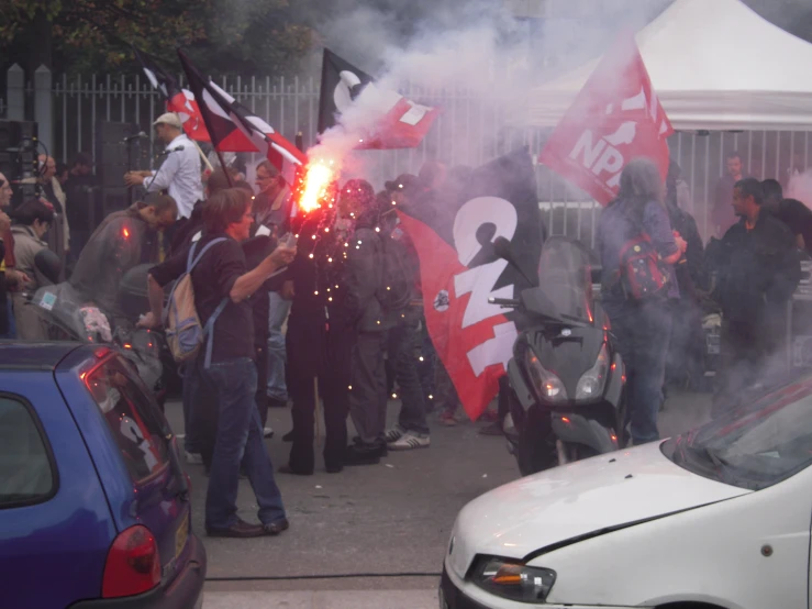 the guy on the motorcycle holds onto some flags