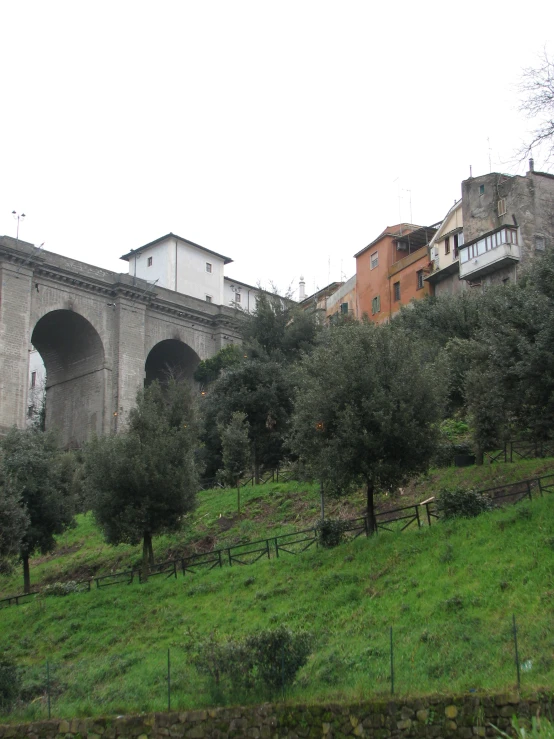 a grassy hill next to an old bridge