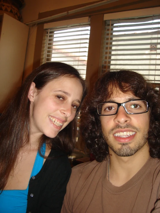 a man and a woman smile while posing for the camera