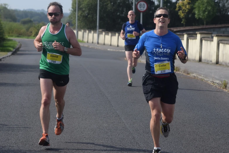 three people running together in a road