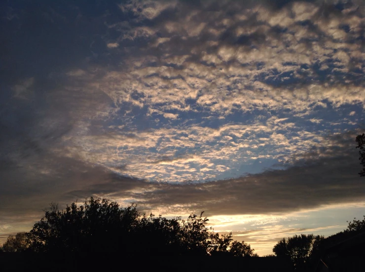 the sun has set behind a cloudy sky