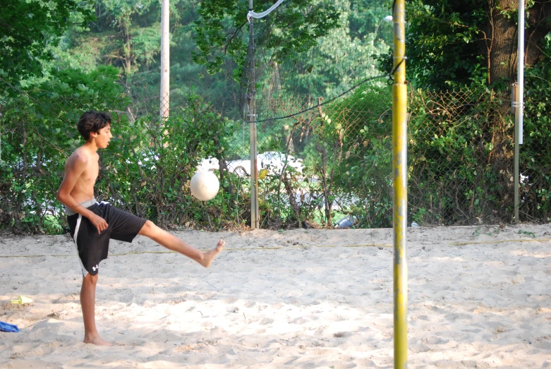 a man kicking a soccer ball across a field