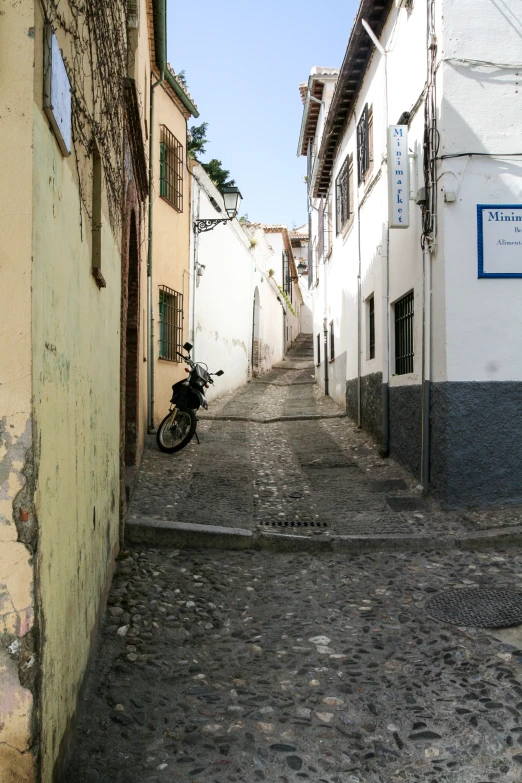 a motorcycle parked in the alley way of a building