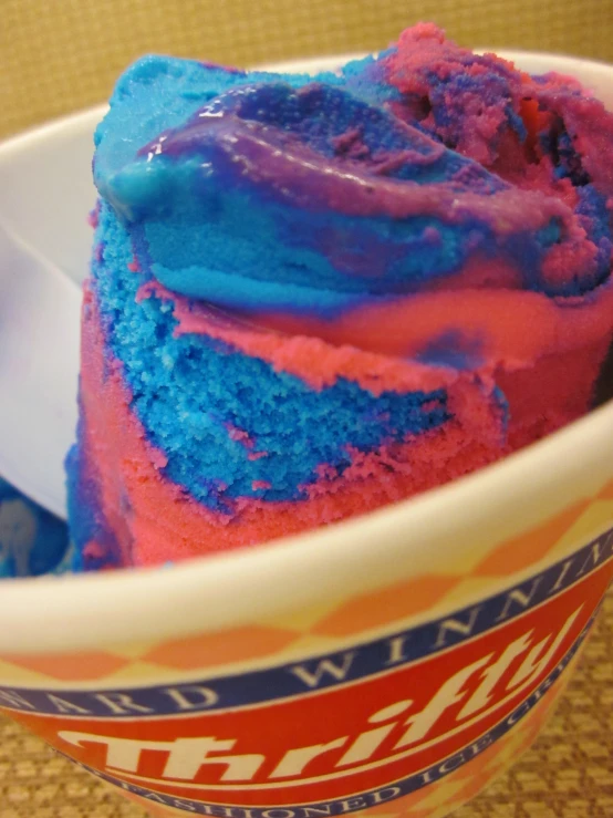 a bowl with a pink and blue cake inside