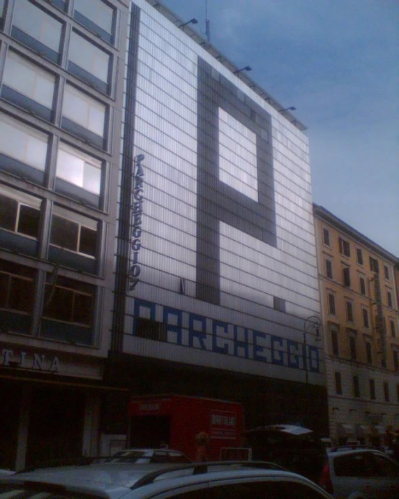 the side of a large building next to parked cars