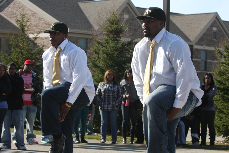 two men with long ties are balancing on their skateboards in front of a crowd