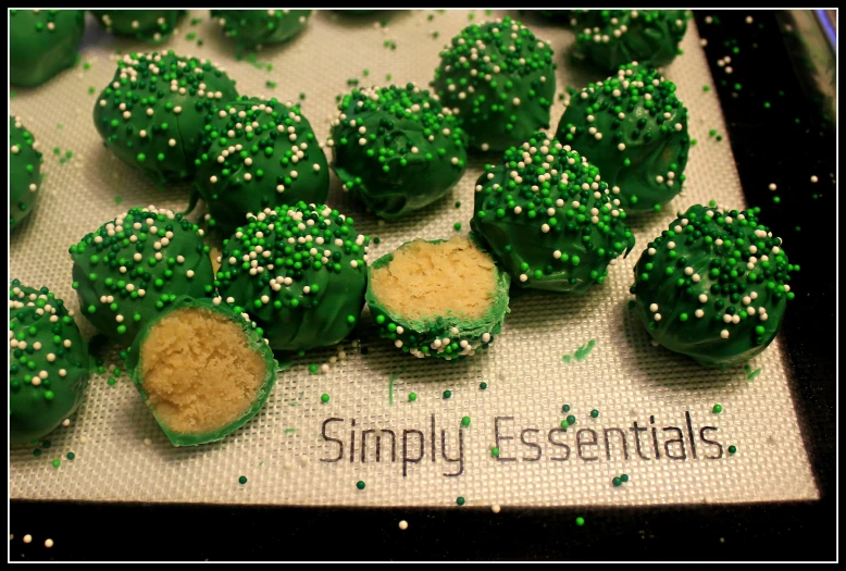 small green desserts on white paper with white sprinkles