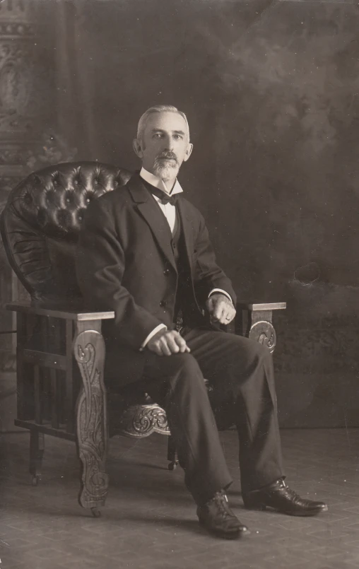 a man sitting in a chair and wearing a suit