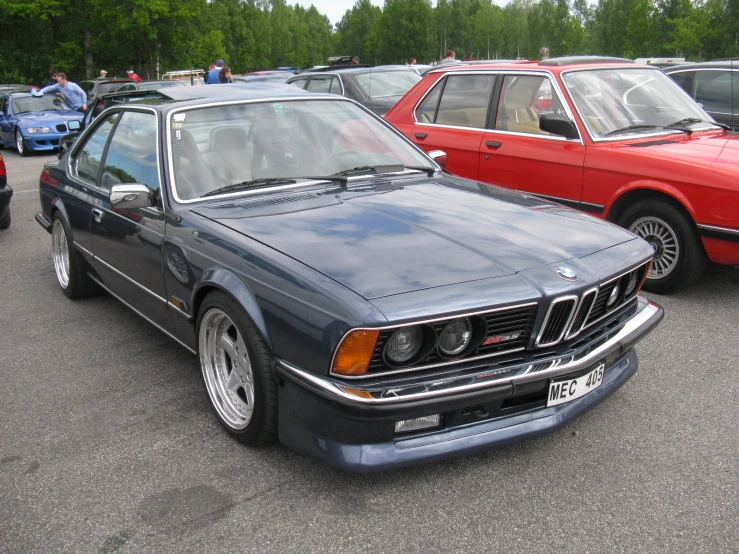 an old bmw car parked in a parking lot