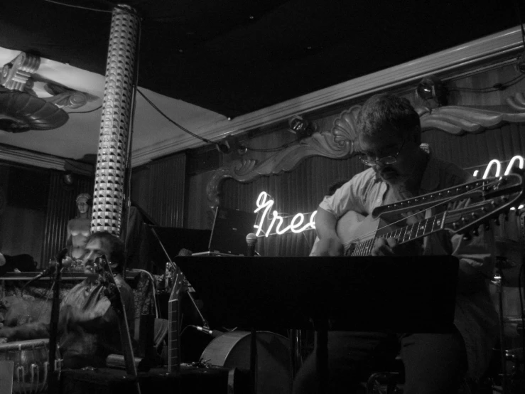 two musicians are playing music under the neon lights