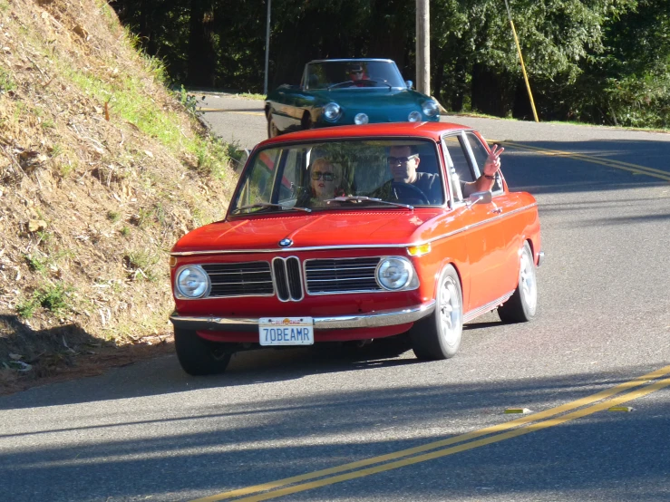 an orange car is being driven on a road