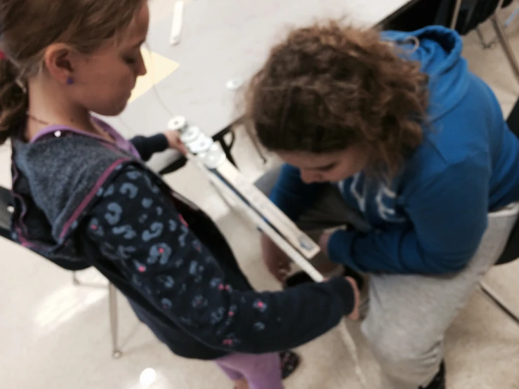 a young child and adult playing a video game on their phones