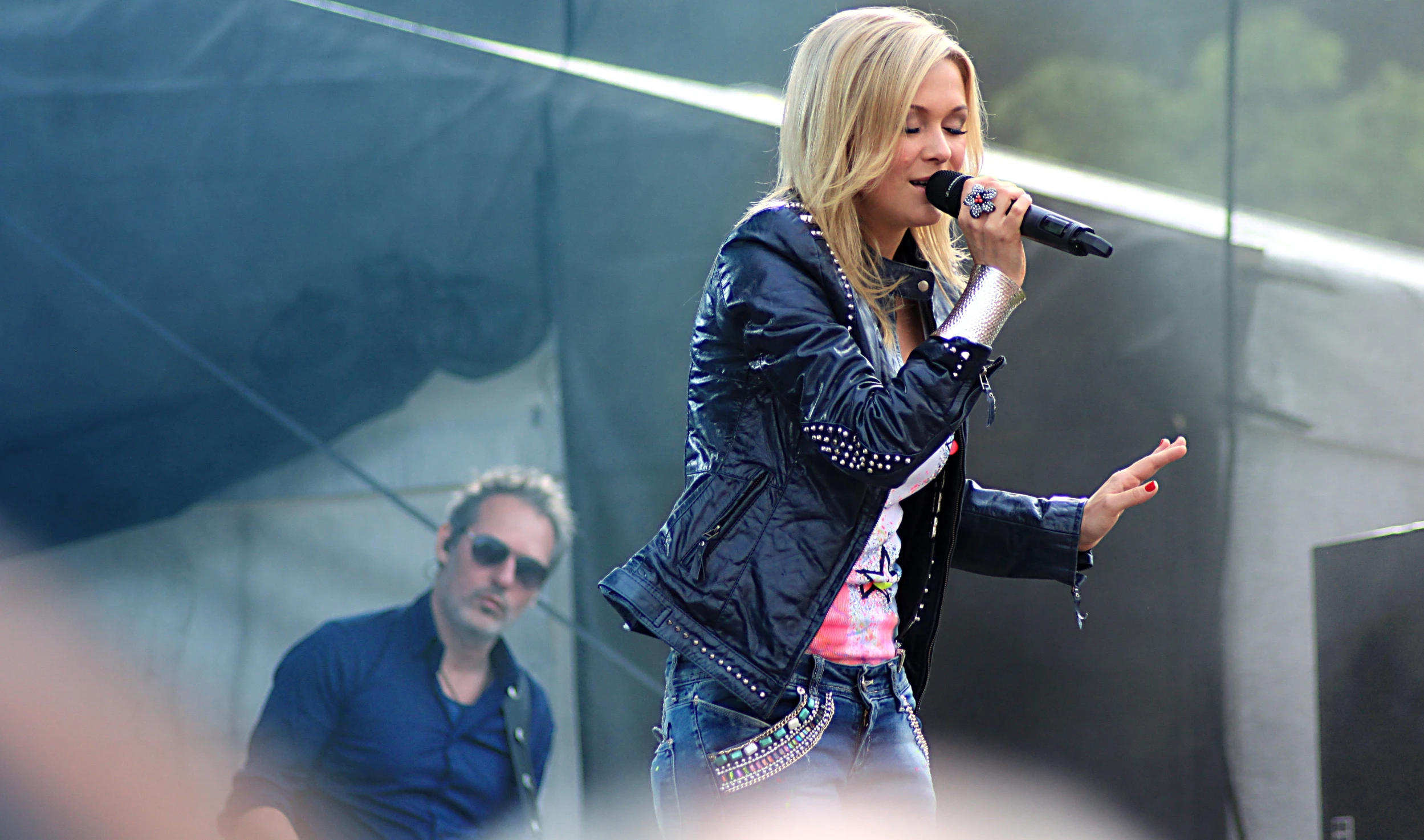 the woman is singing into her microphone on the stage