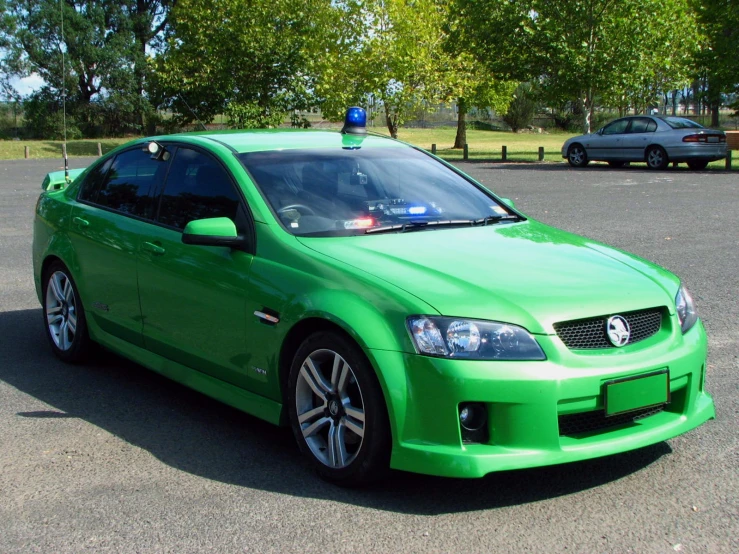 a green car that is parked in a parking lot