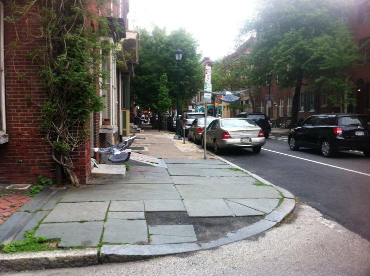 an empty sidewalk along the road in a small city