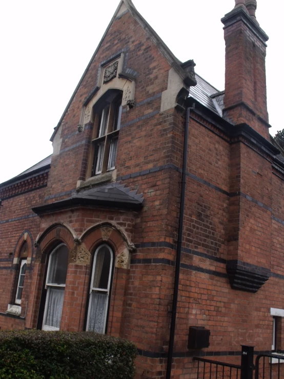 an old brick building with a black gate and windows