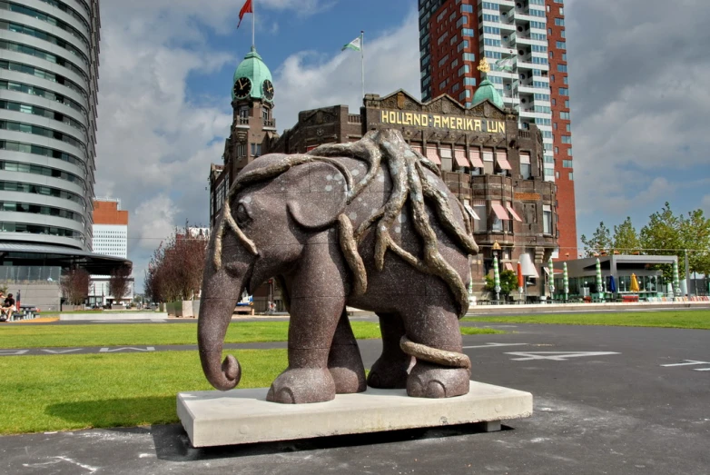 an elephant statue with buildings in the background