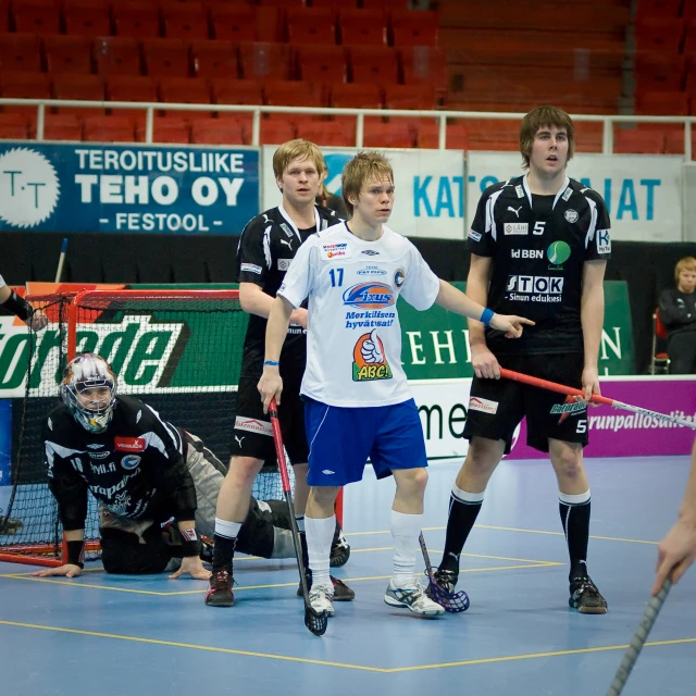 several players in a doubles match playing field hockey