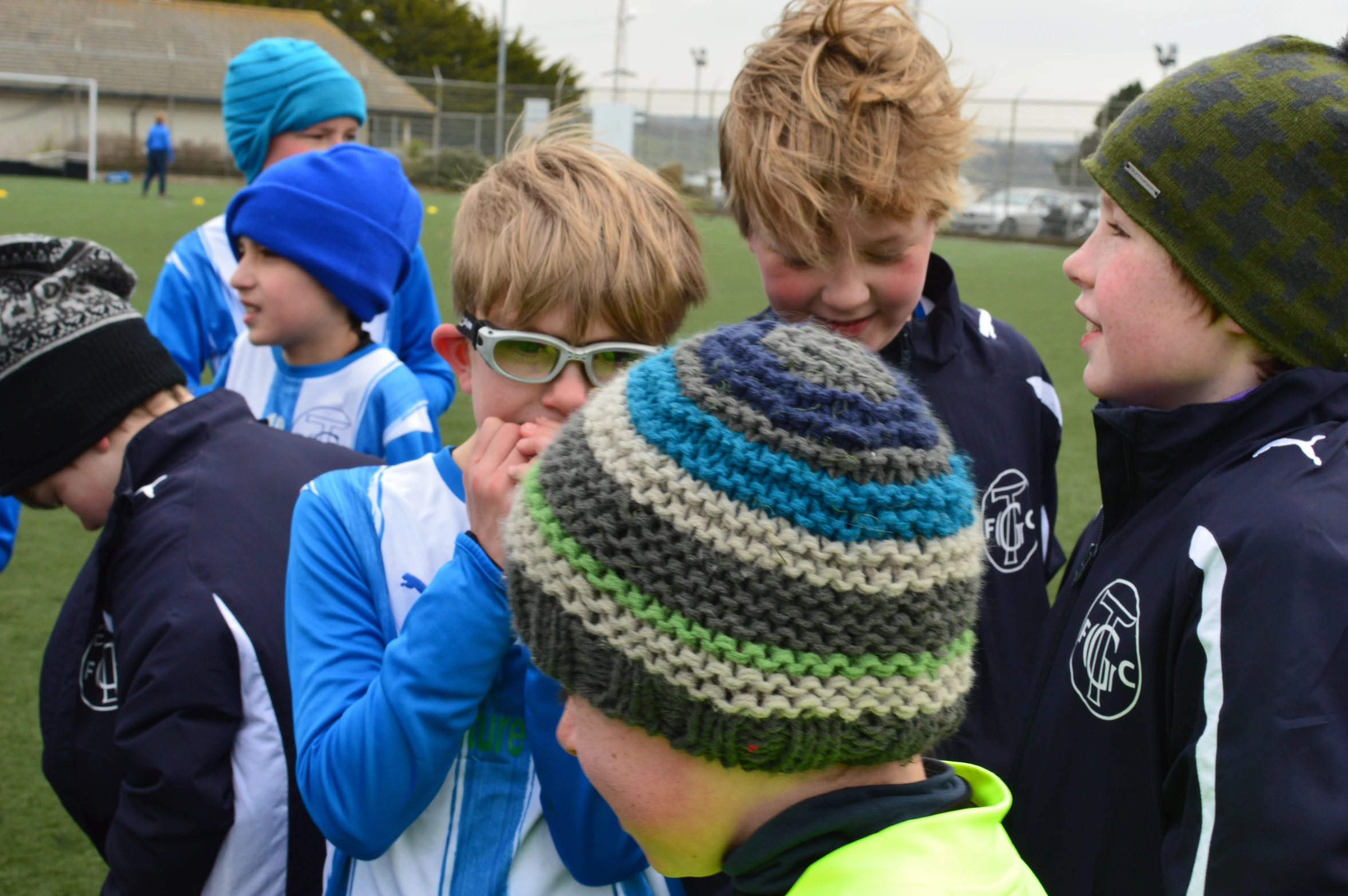 several boys are standing near each other on a soccer field