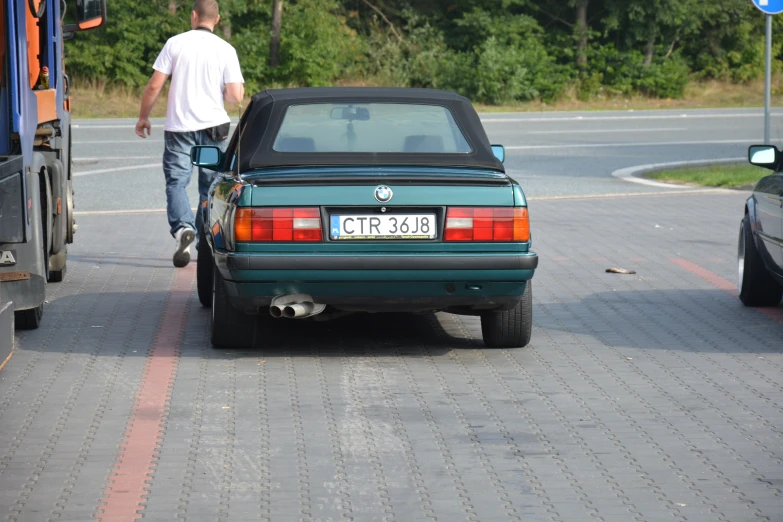 a man that is walking up to a car