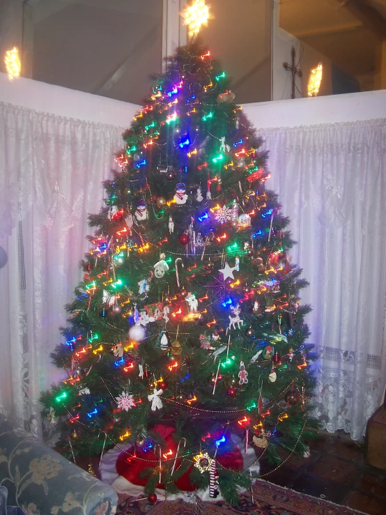 a very lite brightly colored christmas tree in a house