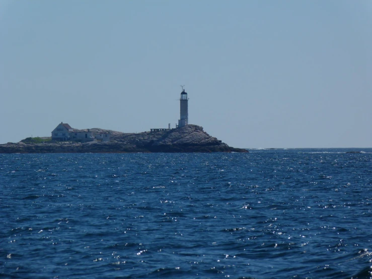 an island with a lighthouse in the middle of the ocean