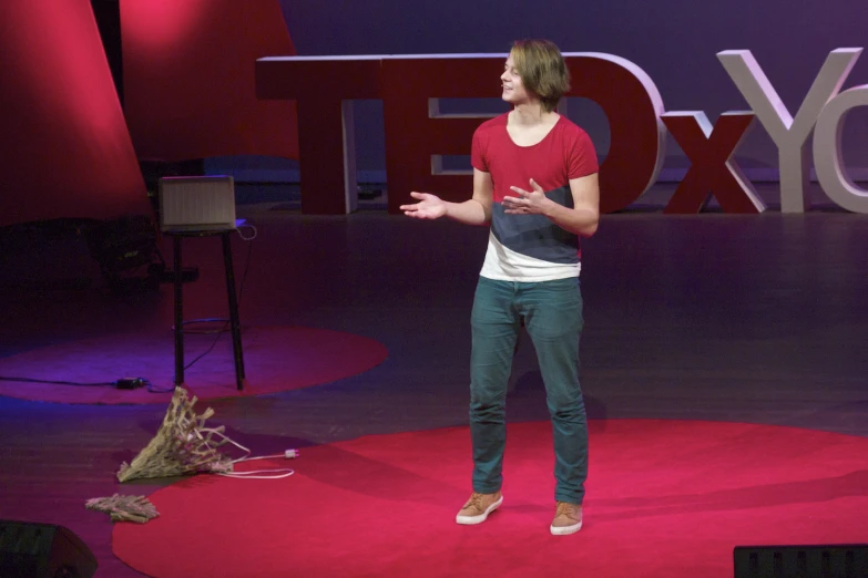 woman talking on stage wearing leggings and red shirt