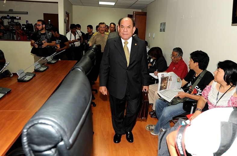 a man is walking through an office with microphones