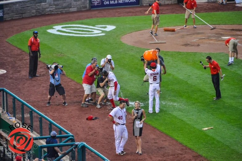 baseball players standing around the field as they talk