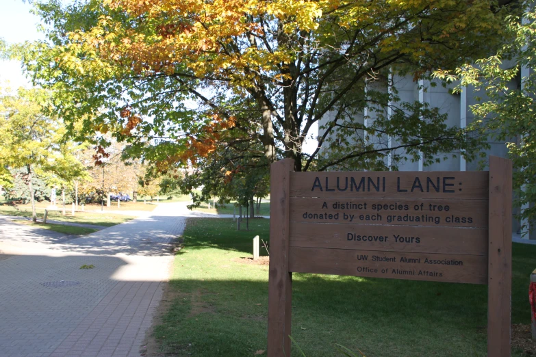 a sidewalk is by a big building with trees in front