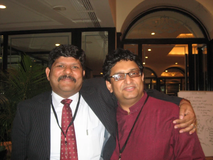 two men dressed nicely in formal attire smiling