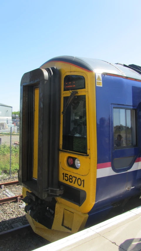 a blue and yellow train stopped at a train station