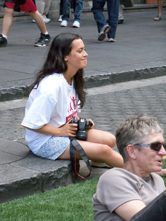 a woman is sitting on the ground talking to a man