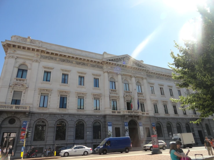 a white building with cars parked outside on the street