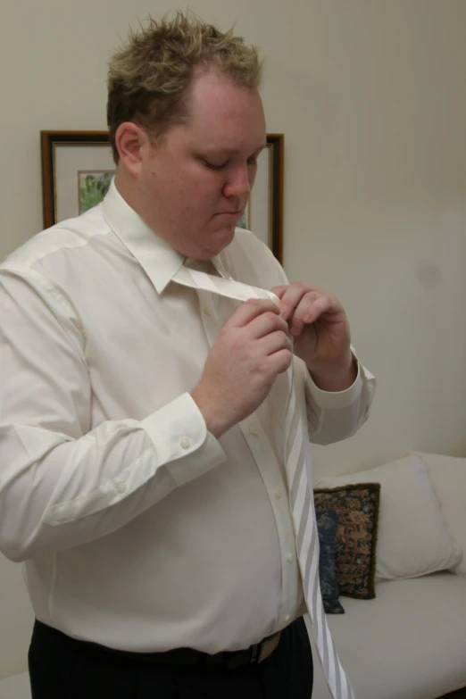 a man straightening his tie while looking at a mirror