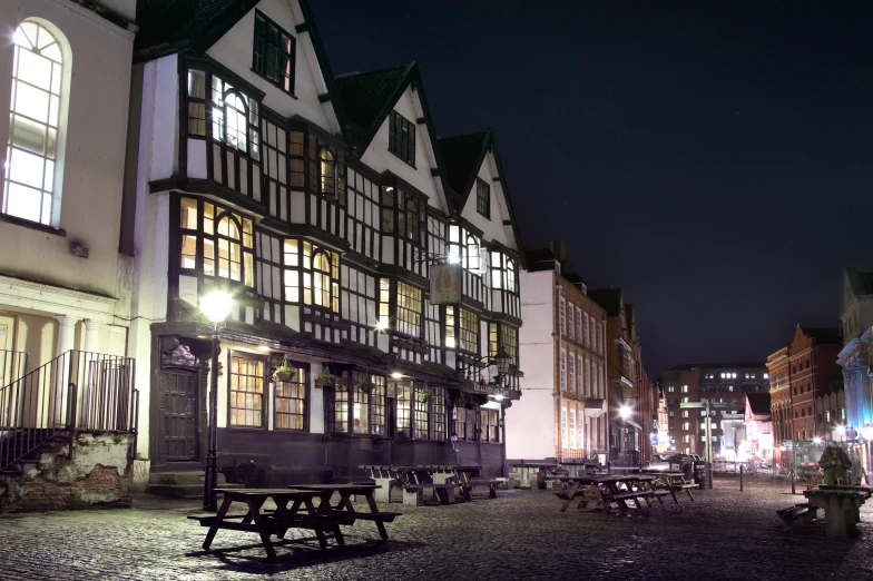 a street in the city at night with several tables