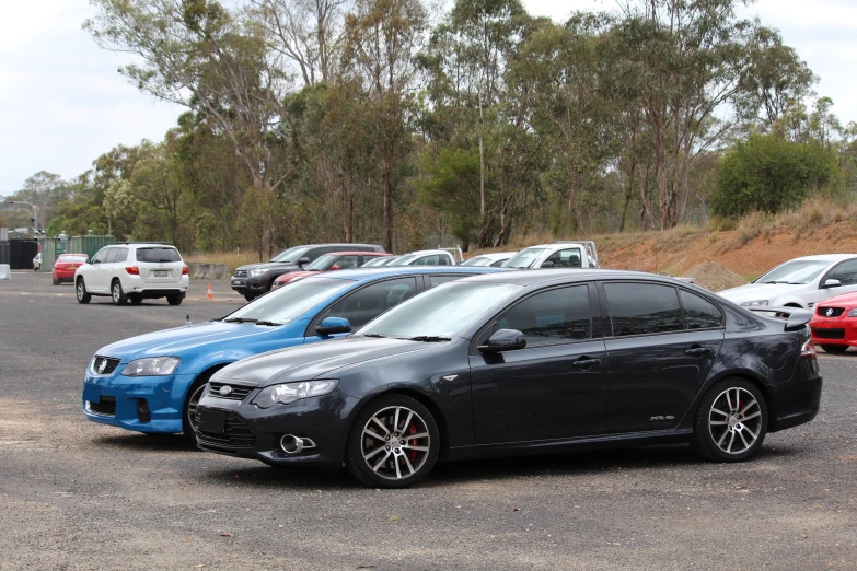 many cars parked in a parking lot next to trees